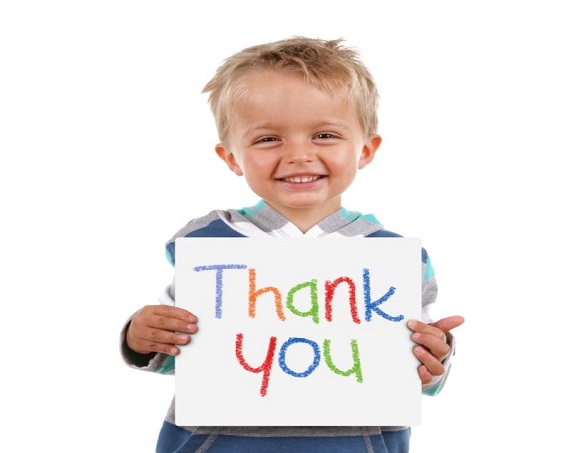 Child holding a crayon thank you sign standing against white background